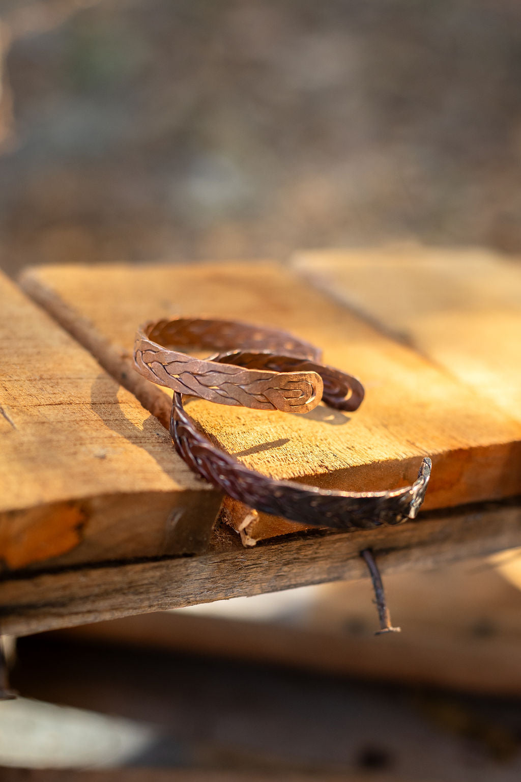 Copper bracelet on a wooden surface with a blurred natural background